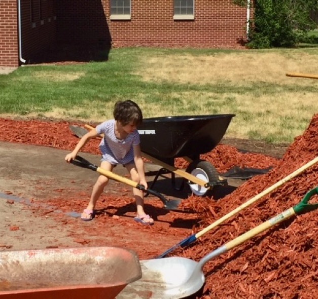 Shannon shoveling wood chips